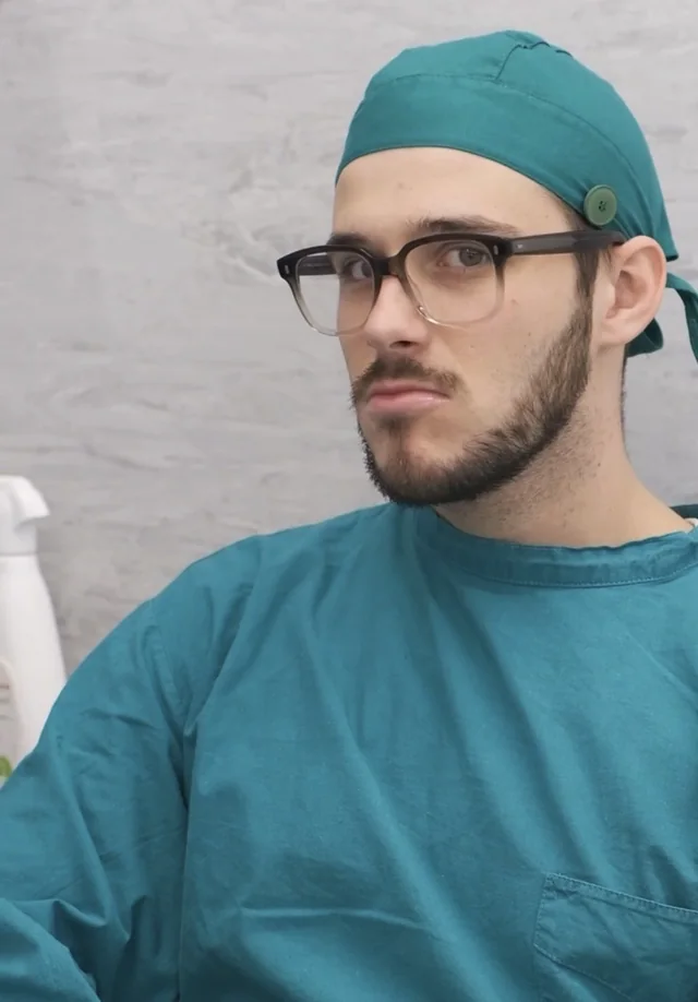 Luca interpreta un medico con camice e copricapo verdi